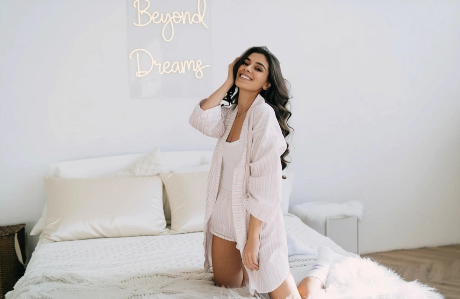 Woman in a white robe sitting on a bed with 'Beyond Dreams' text above.